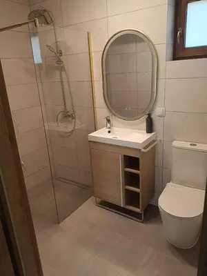 a bathroom with a shower and a sink and a mirror at Domki na Górkach in Spytkowice