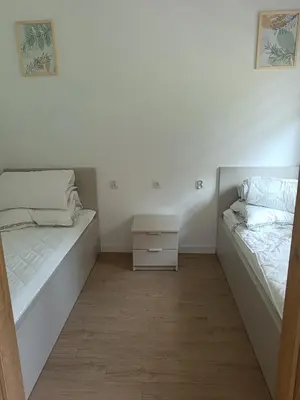 a bedroom with two beds and a night stand at Domki na Górkach in Spytkowice