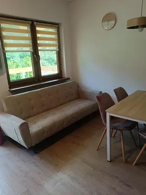 a living room with a couch and a table at Domki na Górkach in Spytkowice