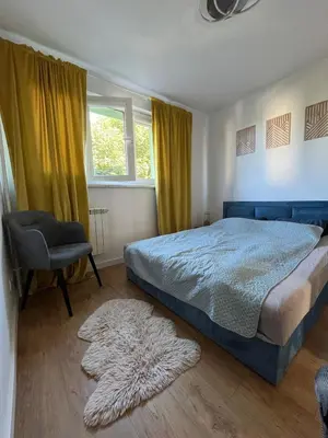 a bedroom with a bed and a chair and a window at Pet-friendly 4-person apartment in Oświęcim