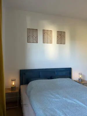 a bedroom with a blue bed with three pictures on the wall at Pet-friendly 4-person apartment in Oświęcim