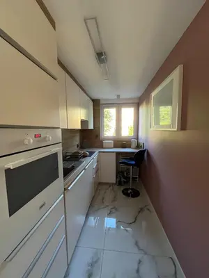 a small kitchen with marble flooring and a window at Pet-friendly 4-person apartment in Oświęcim