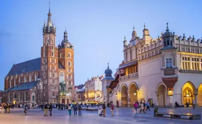 a group of people walking around a city with buildings at Old Town Kraków by Downtown Apartments in Kraków