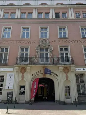 a large pink building with a sign on it at Old Town Kraków by Downtown Apartments in Kraków