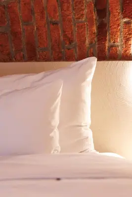 a white pillow sitting on top of a bed at Nomadic Lite in Kraków