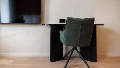 a green chair sitting in front of a tv at Nomadic Lite in Kraków