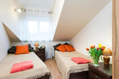a attic bedroom with two beds with colorful pillows at Vanilla 3, 4bdr 2bth apartment 5min to Main Square in Kraków