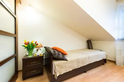 a bedroom with a bed and a table with a vase of flowers at Vanilla 3, 4bdr 2bth apartment 5min to Main Square in Kraków