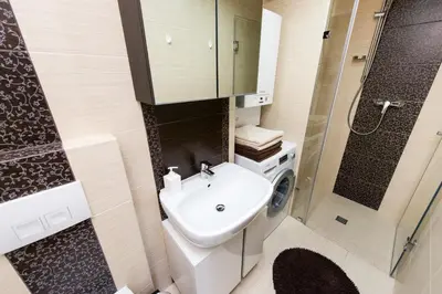 a bathroom with a sink and a washing machine at Vanilla 3, 4bdr 2bth apartment 5min to Main Square in Kraków