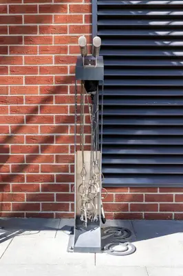 a bird feeder with chains hanging from a brick wall at Apartament Orawska U Pana Cogito in Kraków