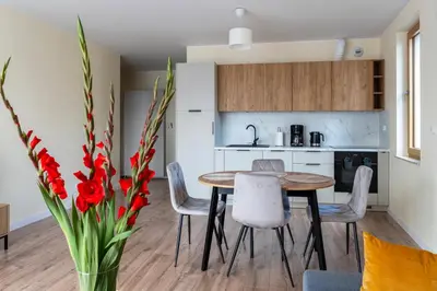 a kitchen and dining room with a table and chairs at Apartament Orawska U Pana Cogito in Kraków