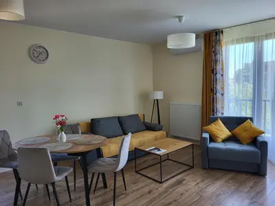 a living room with a couch and a table and chairs at Apartament Orawska U Pana Cogito in Kraków