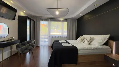 a bedroom with a bed and a table and chairs at Apartamenty Oracka Przystań Solna 2 in Bochnia
