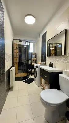 a bathroom with a toilet and a sink and a mirror at Apartamenty Oracka Przystań Solna 2 in Bochnia