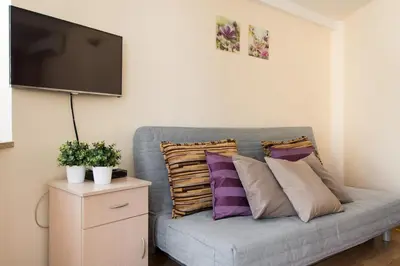 a grey couch with pillows and a flat screen tv at Vanilla 4, 3bdr 1,5bth apartment in city centre in Kraków