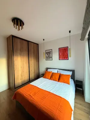 a bedroom with a large bed with orange pillows at Novum Escape in Kraków