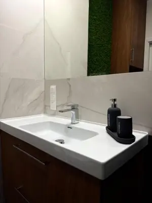 a bathroom with a white sink and a mirror at Novum Escape in Kraków