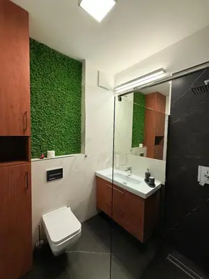 a bathroom with a toilet and a green wall at Novum Escape in Kraków
