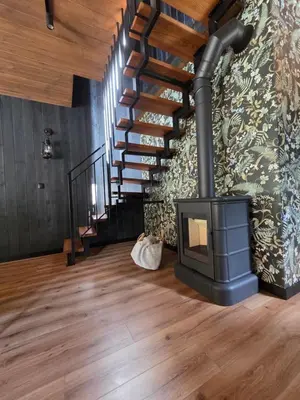 a wood stove in a room with a staircase at Chillout Kocoń nowoczesny dom w górach in Kocoń