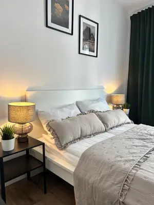 a bed in a bedroom with two lamps on a table at Vetaluniego Apartment High quality in Kraków