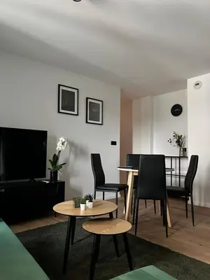 a living room with a table and chairs and a television at Vetaluniego Apartment High quality in Kraków