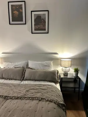 a bedroom with a bed with two pictures on the wall at Vetaluniego Apartment High quality in Kraków