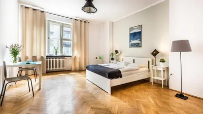 a bedroom with a bed and a desk and a chair at Sereno Apartments in Kraków