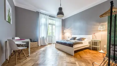 a bedroom with a bed and a table and chairs at Sereno Apartments in Kraków