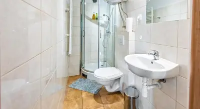 a bathroom with a toilet and a shower and a sink at Sereno Apartments in Kraków
