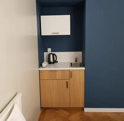 a small kitchen with a sink and a blue wall at Sereno Apartments in Kraków