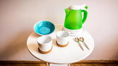 a white table with cups and a green blender at Sereno Apartments in Kraków