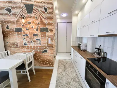 a kitchen with a table and a brick wall at Old Town Apt - Traugutta Street flat 5 in Kraków