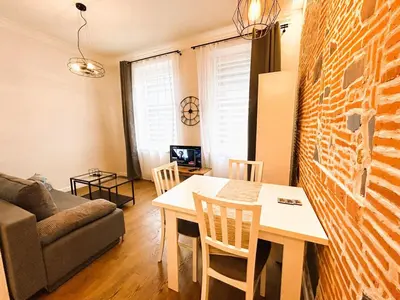 a living room with a table and a brick wall at Old Town Apt - Traugutta Street flat 5 in Kraków