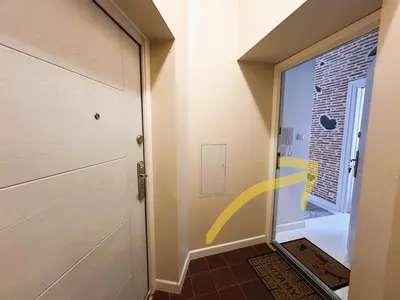 a hallway with a door with a yellow arrow painted on it at Old Town Apt - Traugutta Street flat 5 in Kraków