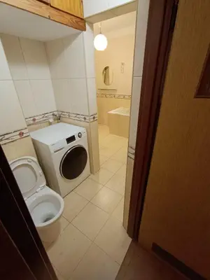 a bathroom with a toilet and a washing machine at Apartament Żmiąca in Jaworzna