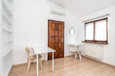a room with a desk and a table and a window at RentPlanet - Apartament przy Plantach in Kraków