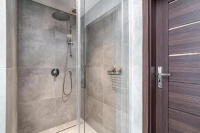 a bathroom with a shower with a glass door at RentPlanet - Apartament przy Plantach in Kraków