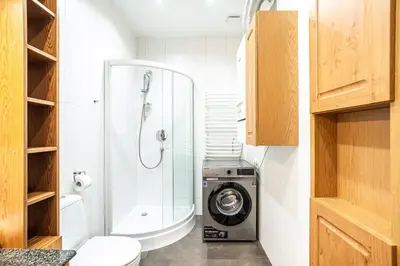 a bathroom with a shower and a washing machine at RentPlanet - Apartament przy Plantach in Kraków
