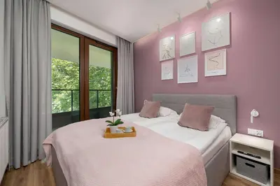 a bedroom with two beds and a window at Cosy Apartment in Cracow with Parking, Desk and Balcony by Noclegi Renters in Kraków