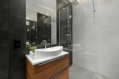 a bathroom with a white sink and a shower at Cosy Apartment in Cracow with Parking, Desk and Balcony by Noclegi Renters in Kraków
