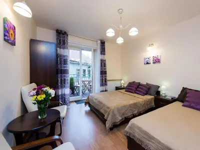 a bedroom with two beds and a table with flowers at Vanilla 2, 3bdr 2bth apartment 5min to Main Square in Kraków