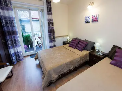 a bedroom with a large bed with purple pillows at Vanilla 2, 3bdr 2bth apartment 5min to Main Square in Kraków
