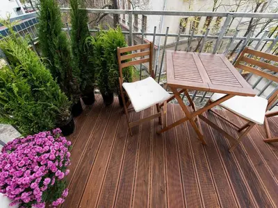 a wooden deck with a table and chairs and flowers at Vanilla 2, 3bdr 2bth apartment 5min to Main Square in Kraków