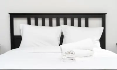 a bed with white pillows and towels on it at Starowiślna Harmony Apartment by BookingHost in Kraków