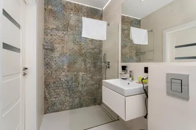 a bathroom with a toilet sink and a washing machine at Starowiślna Harmony Apartment by BookingHost in Kraków