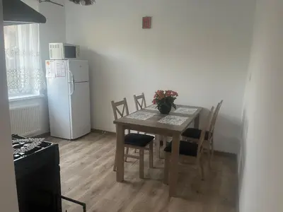 a kitchen with a table and a white refrigerator at u Wiktorii in Sąspów
