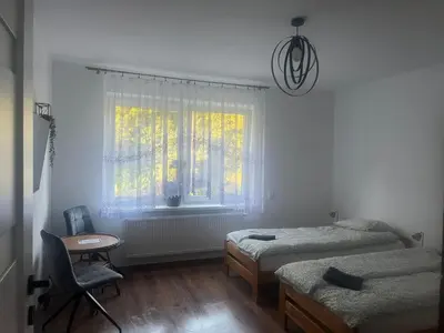 a bedroom with two twin beds and a window at u Wiktorii in Sąspów