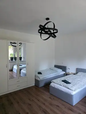 a bedroom with two beds and a chandelier at u Wiktorii in Sąspów