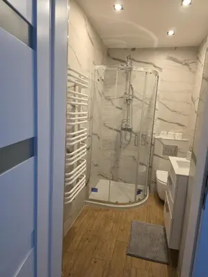 a bathroom with a shower with a glass door at u Wiktorii in Sąspów