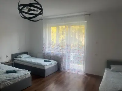 a bedroom with two beds and a window with a chandelier at u Wiktorii in Sąspów